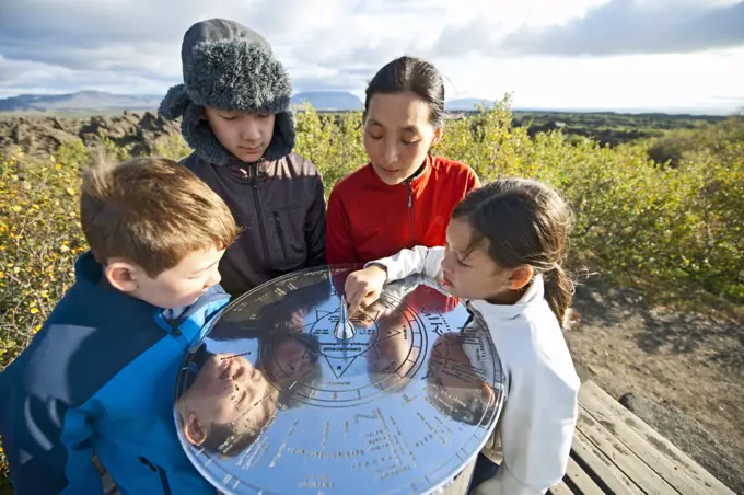 Family checking compass rose at Lake Myvatn