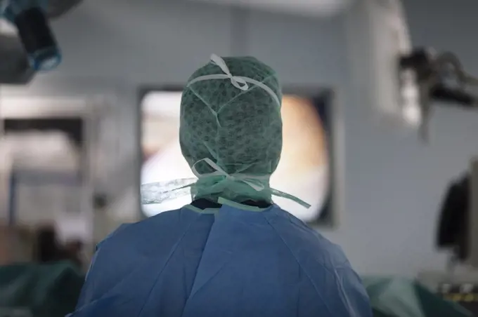 a surgeon looks at a monitor screen during surgery