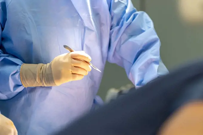 a surgeon holds a scalpel in his hand
