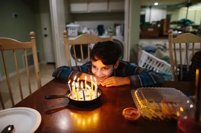 Boy Smiles At The Candles On His Cast Iron Pan Birthday Cake