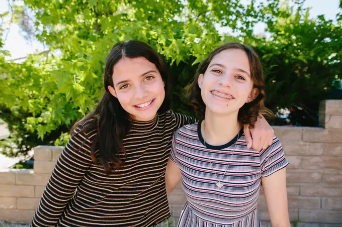 Teen and Tween Sisters Wearing Stripes Smile For The Camera