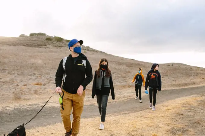 Father And His Three Children Out On A Hike While Wearing Face Masks