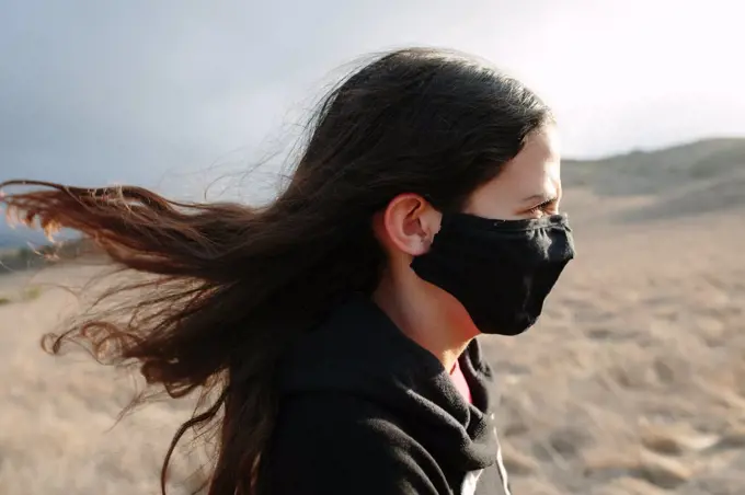 Profile Shot Of A Tween Girl Wearing A Face Mask On A Windy Day