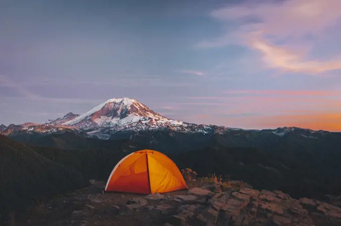 Orange tent on the top of the mountain near mt. Rainier