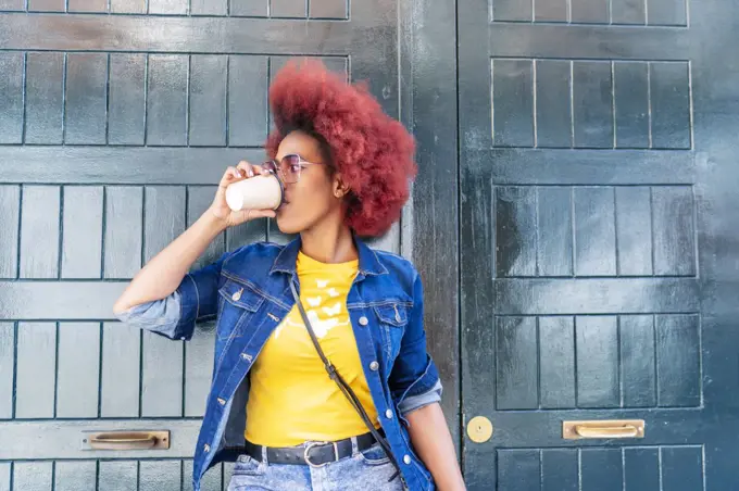 woman with red afro hair having a cup of coffee
