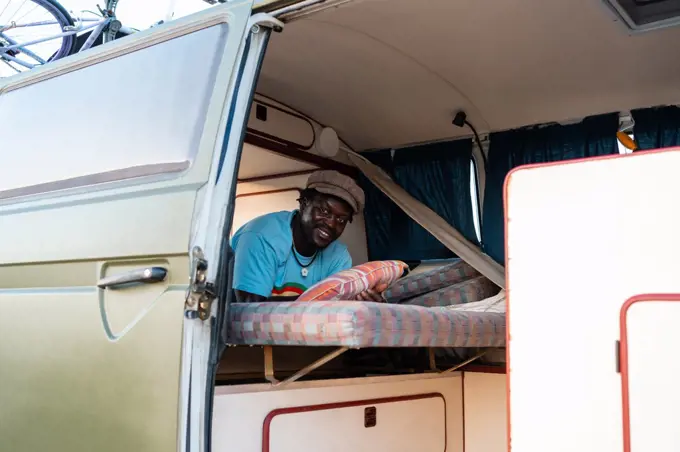 black afro american male person inside his camper van, freedom and tra