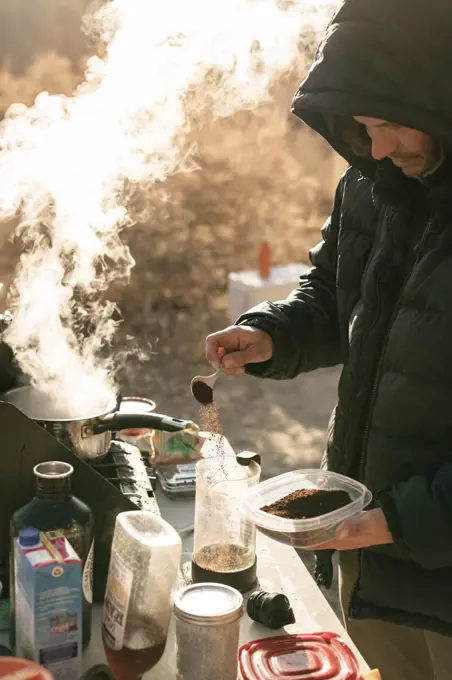 Man preparing coffee while exploring Canyonlands National Park during vacation