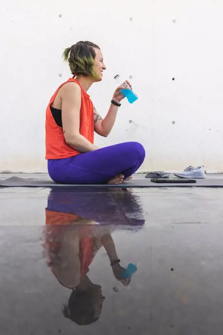 Athlete woman reflecting after a yoga session with isotonic drink