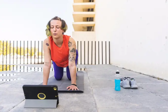 Athlete woman doing cat-cow pose in online class
