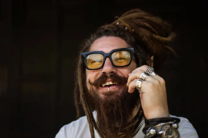 portrait of a hipster guy with glasses and with dreadlocks and a