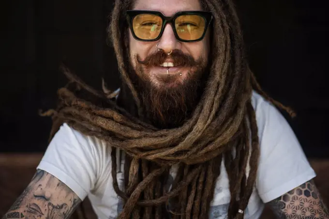 portrait of a hipster guy with glasses and with dreadlocks and a