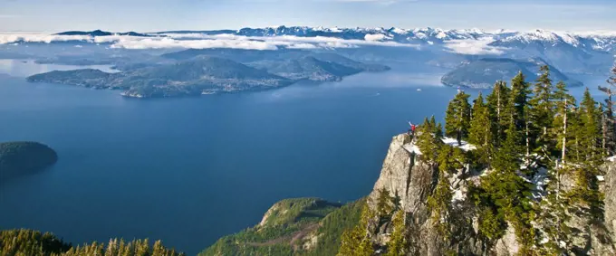 Panoramic view of hiker standing on mountain summit, Vancouver B.C.