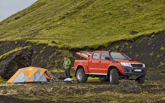couple camping next to their modified pick up truck in Iceland