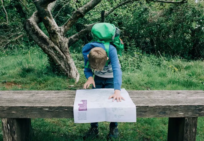 boy looking at a map of the UK whilst exploring the countryside