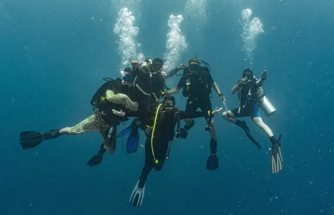 group of divers performing the mandatory safety stop while ascending