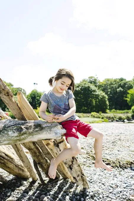 Full length portrait of a young child balancing on driftwood