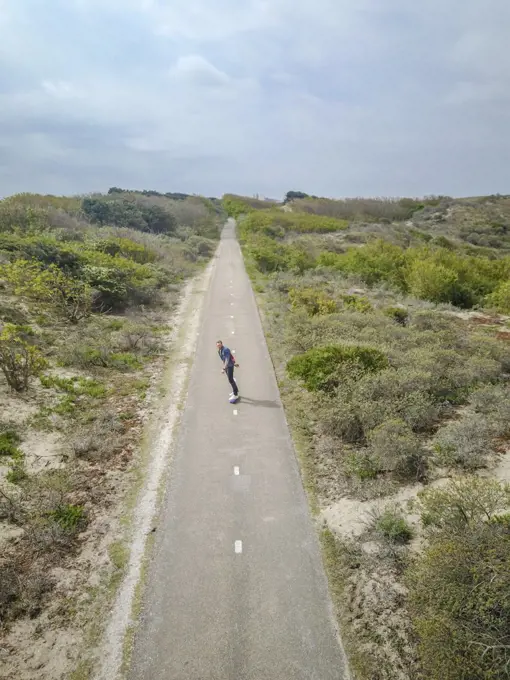 Drone View of an isolated man skating a Countryside straight road