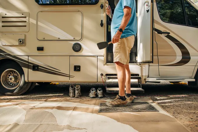 Retired Caucasian man grills outside RV in campground in Utah