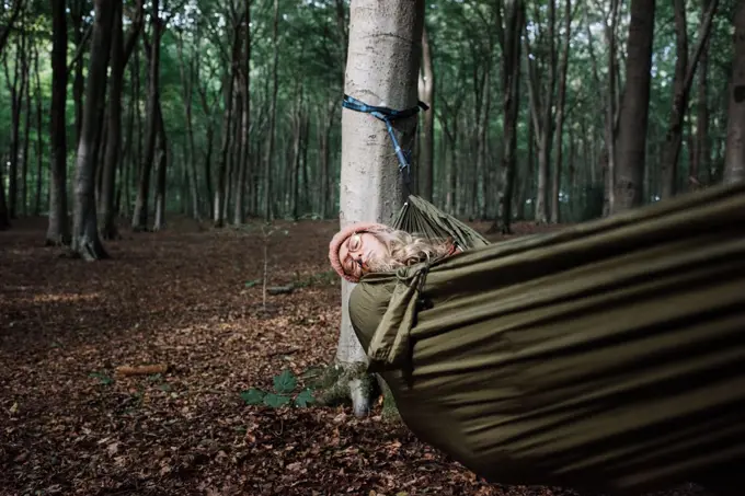 woman laying in a hammock in the forest sleeping