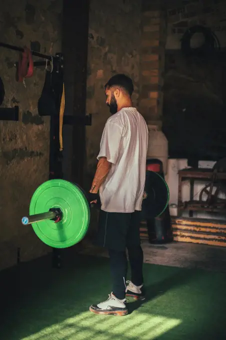 Boy lifting weights in his home gym