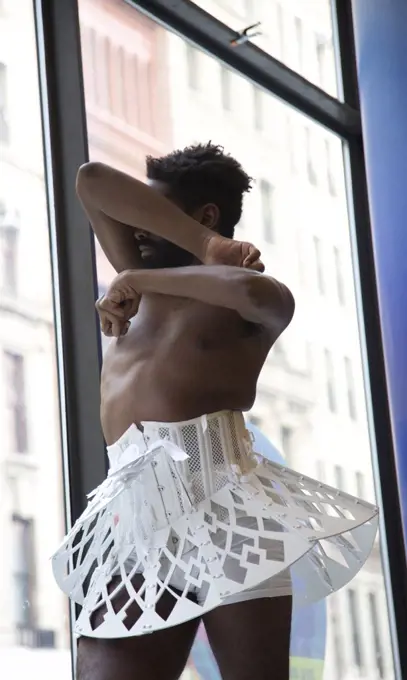 Male Dancer in White Tutu Covering His Face as Window Display