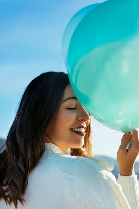 Portrait of a beautiful woman smiling and holding balloons