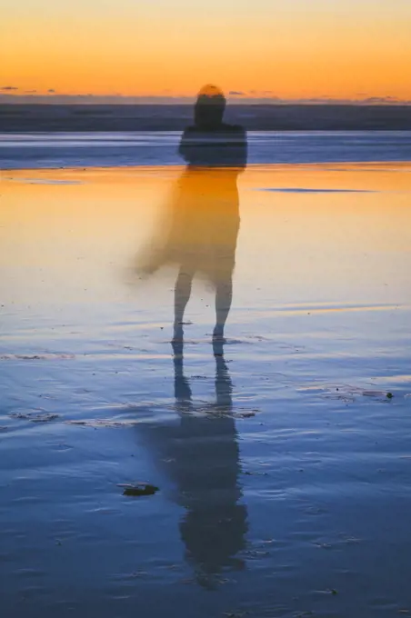 Abstract image of a woman on the beach at sunset