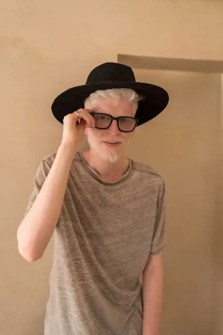 Albino man standing next to the wall portrait