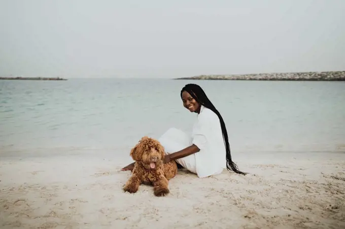 Woman playing with her dog at the beach 