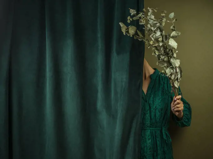 Girl hidden after a green curtain