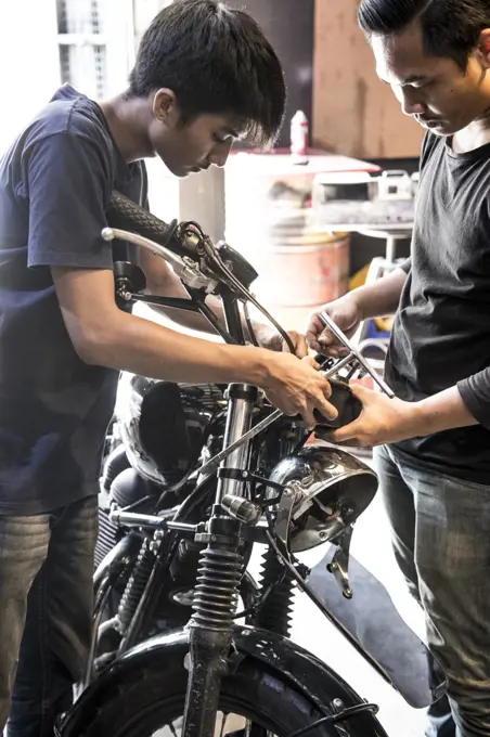 mechanic's working on motorcycle at custom bike shop in Bangkok