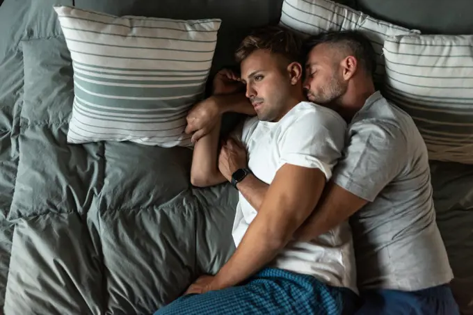 Top view of a male gay couple about to sleep in bed
