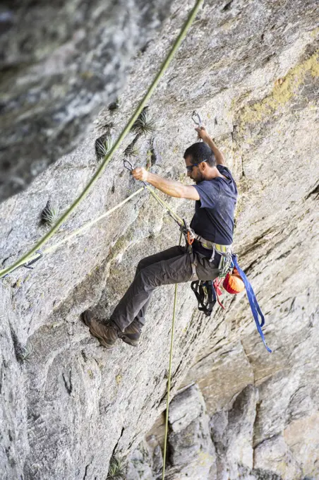 Beautiful view to rock climber climbing on steep rocky wall