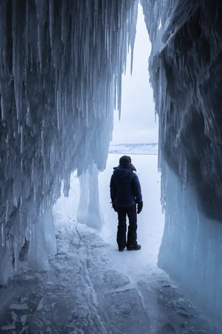 person observe the inmensity of ice outside of ice cave