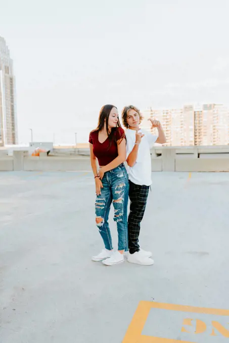 boyfriend and girlfriend being silly standing on a rooftop