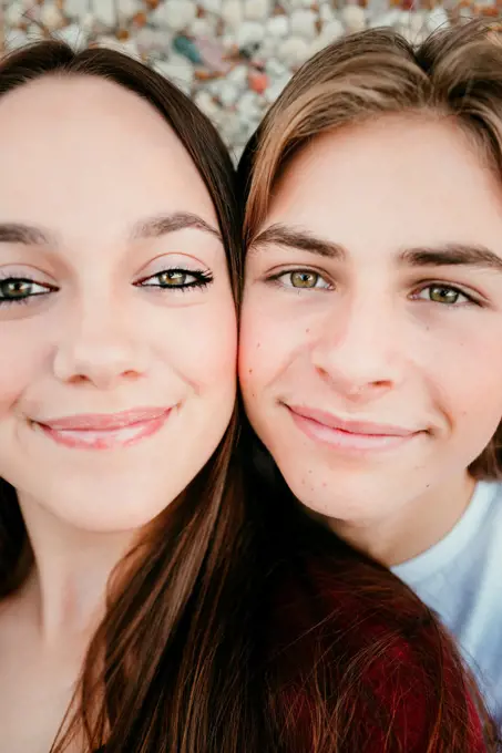 up close view of teen boy face and teen girl face filling the frame