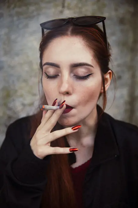 Close-up of a red-haired girl smoking a joint