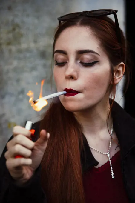 Close-up of a red-haired girl smoking a joint