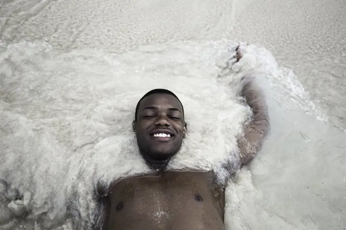 Cheerful black man in sea waves