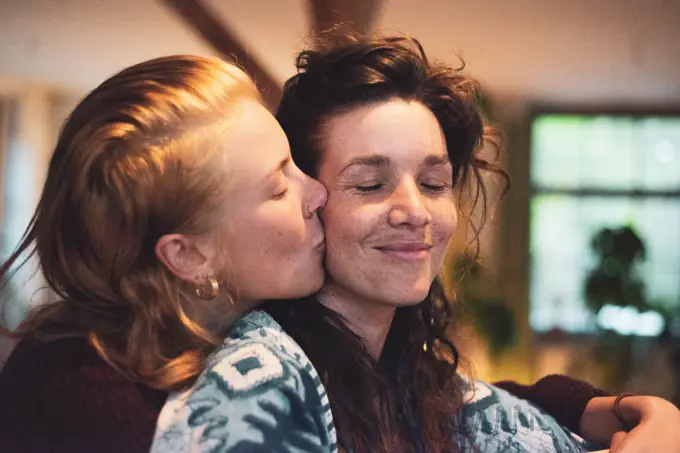 blissful love moment between two queer women cuddling at home