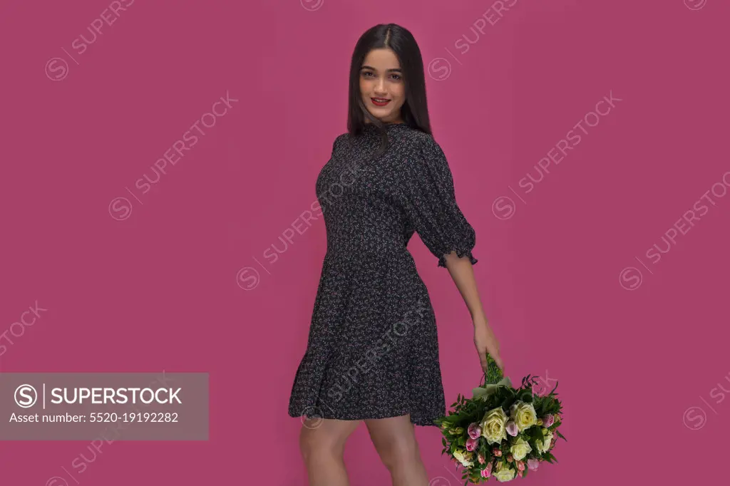 Beautiful girl posing with holding a flower bouquet