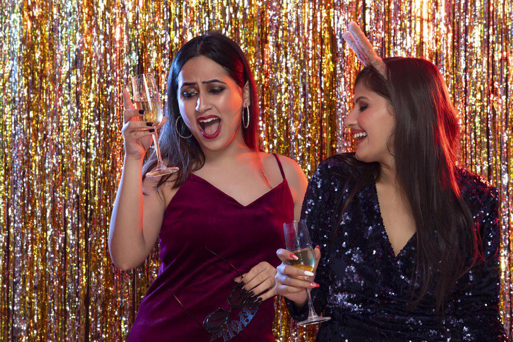 young women holding champagne glass celebrating the New Year party