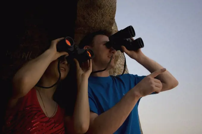 Couple watching through binoculars