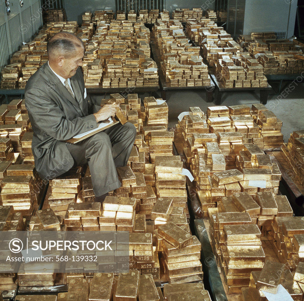 Stock Photo: 568-139332 Side profile of a mature man counting gold bars