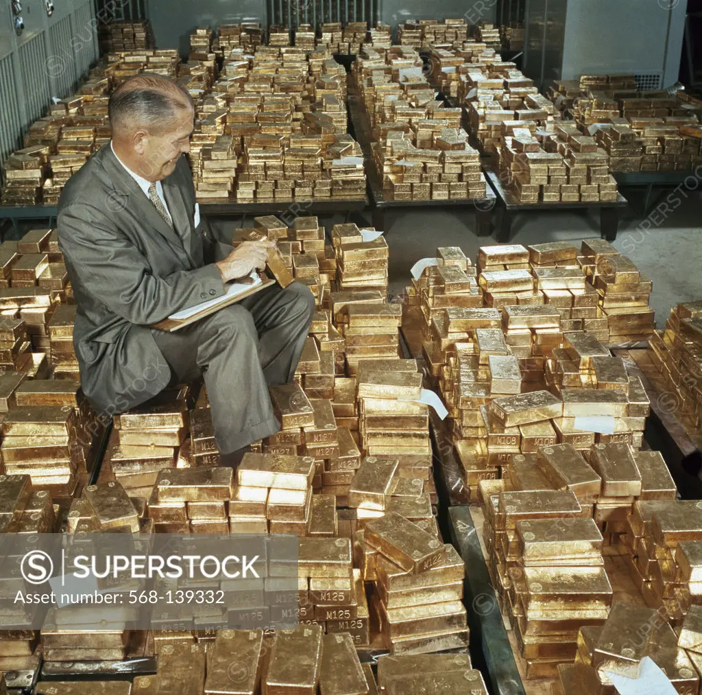 Side profile of a mature man counting gold bars