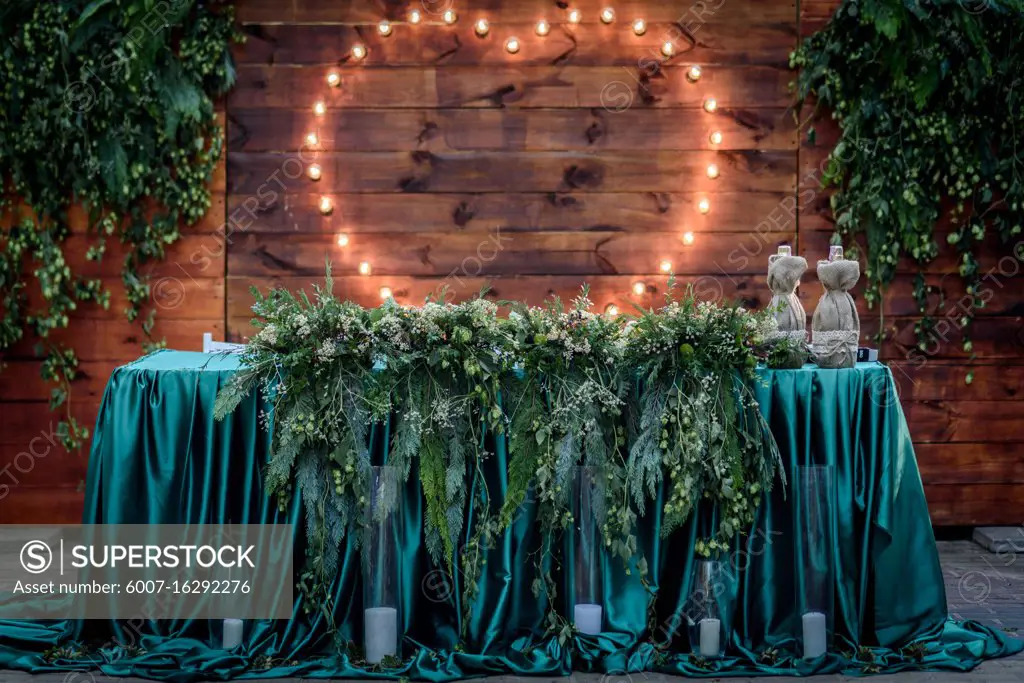 wedding banquet on the background of the heart of the lamps in the forest among the trees on the green track