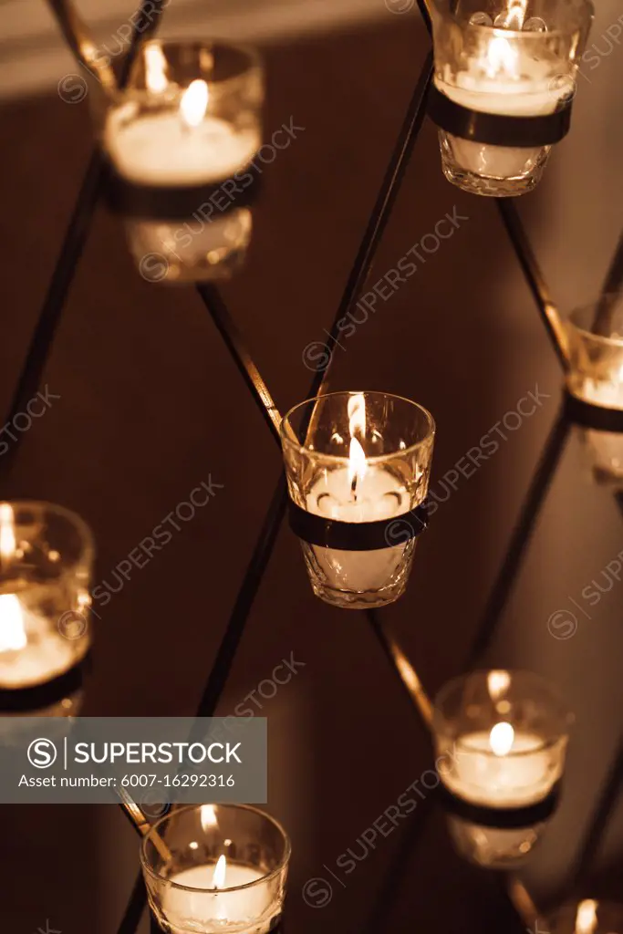 Candles burn in glasses on the wedding arch, wedding decorations