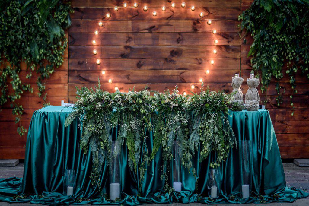 wedding banquet on the background of the heart of the lamps in the forest among the trees on the green track