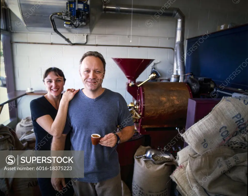 Portrait of coffee master roasters sampling cup of coffee in roasting room