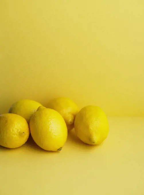 Close up of whole lemons on yellow background